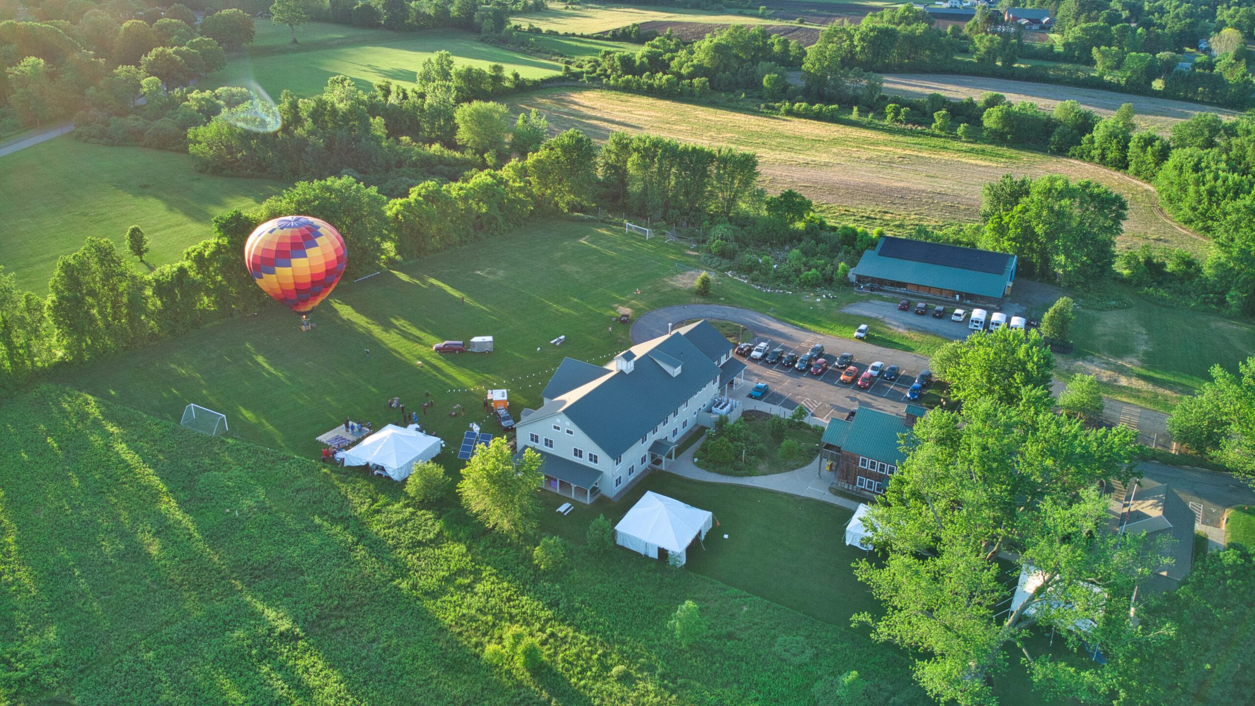 Aerial shot of Four Rivers with campus and fields and a hot air balloon