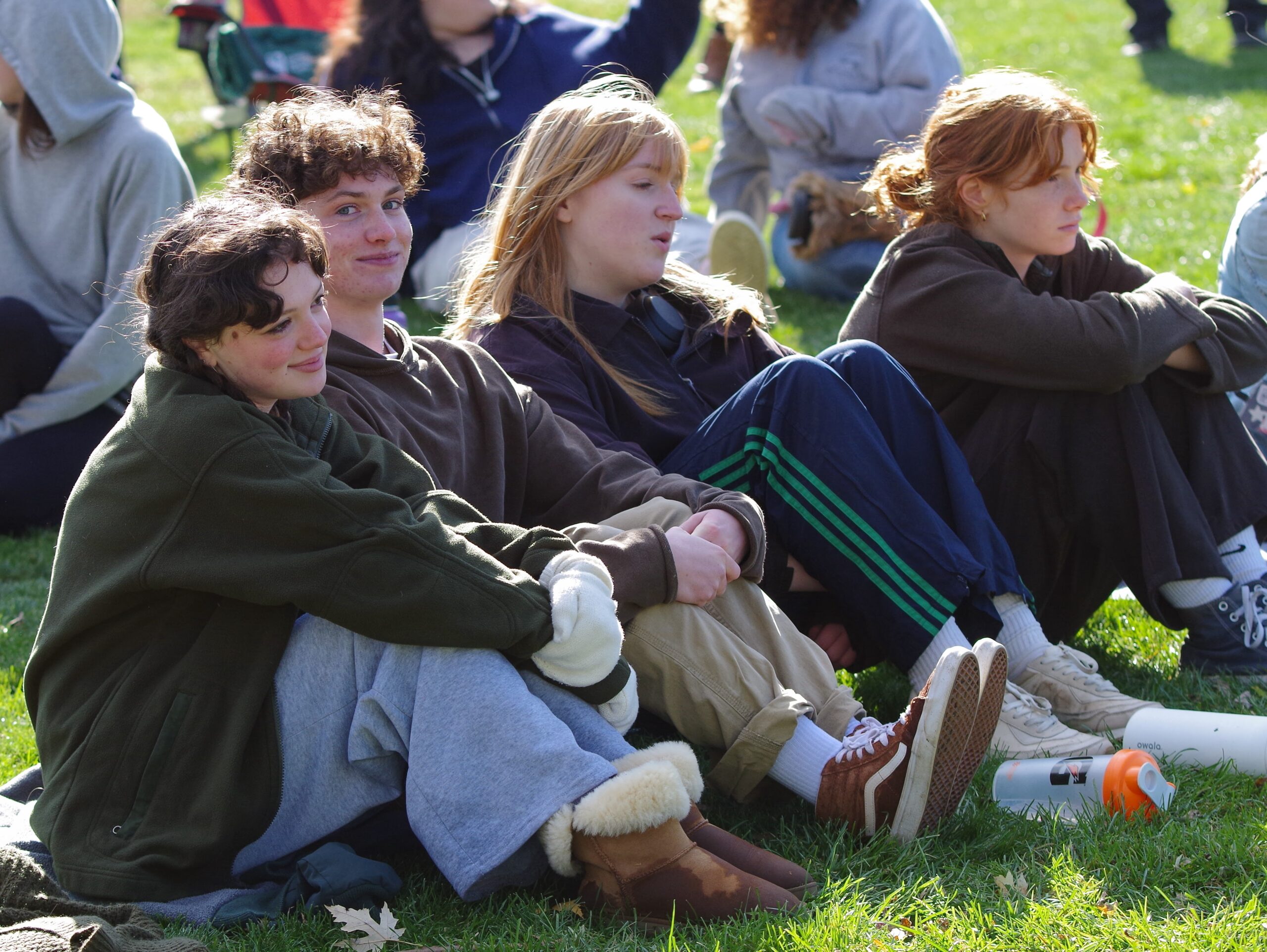 Four students sit on the grass