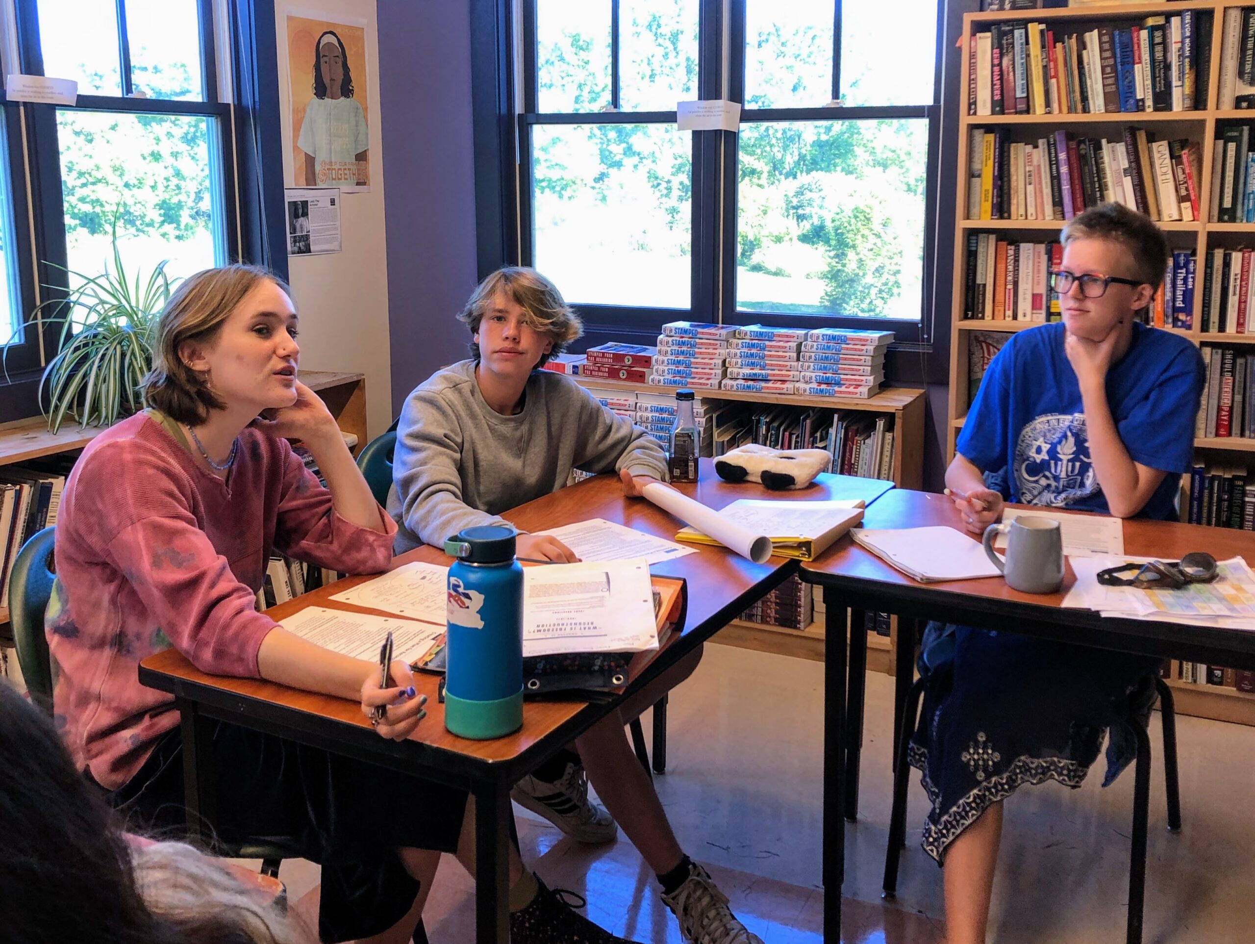 Students sit discussing at a table