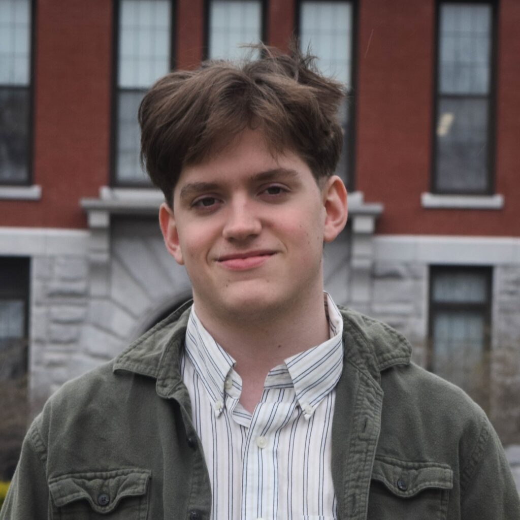 Zach Rutherford stands in front of a building