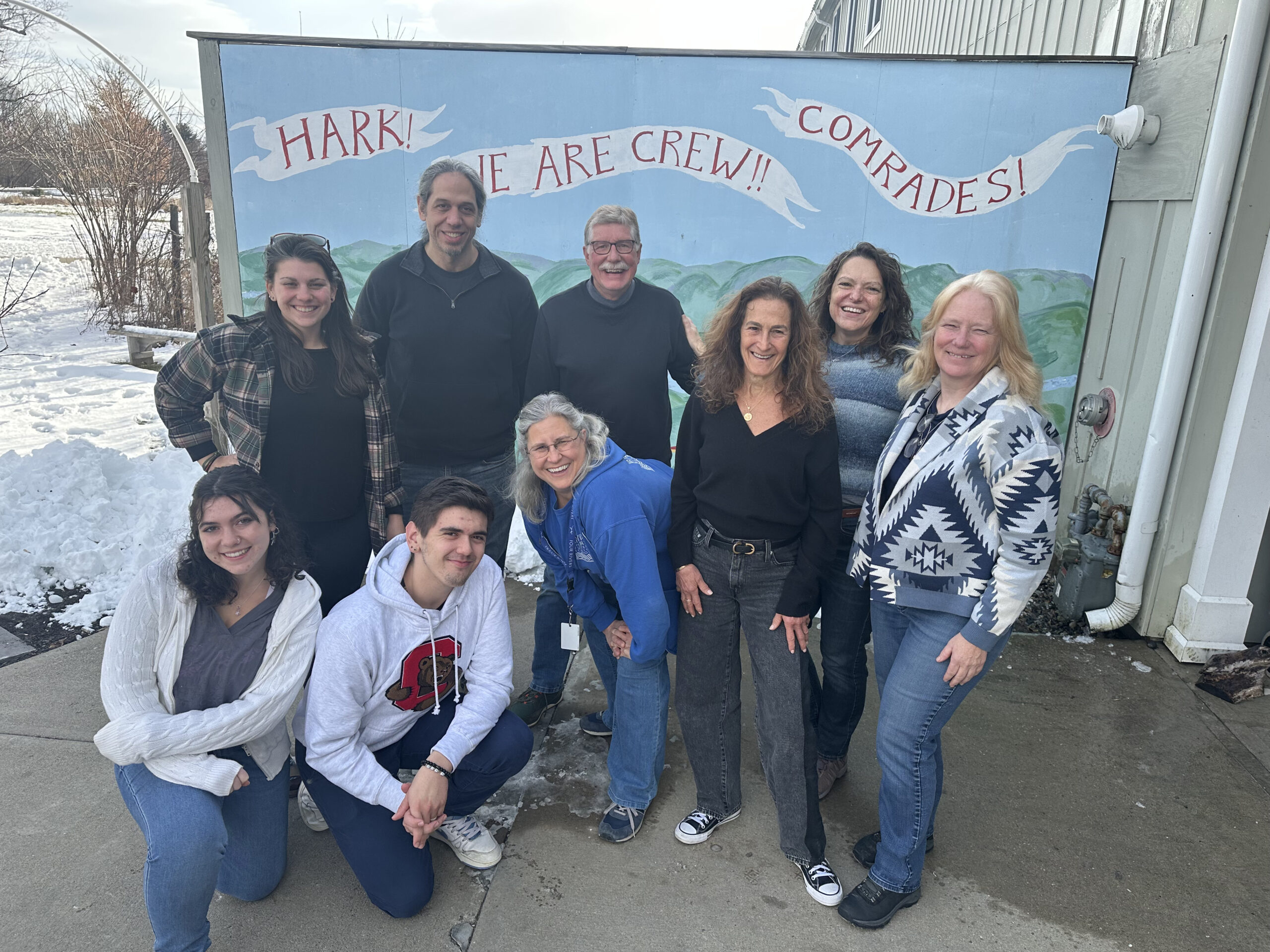 Board of trustees standing in front of a mural